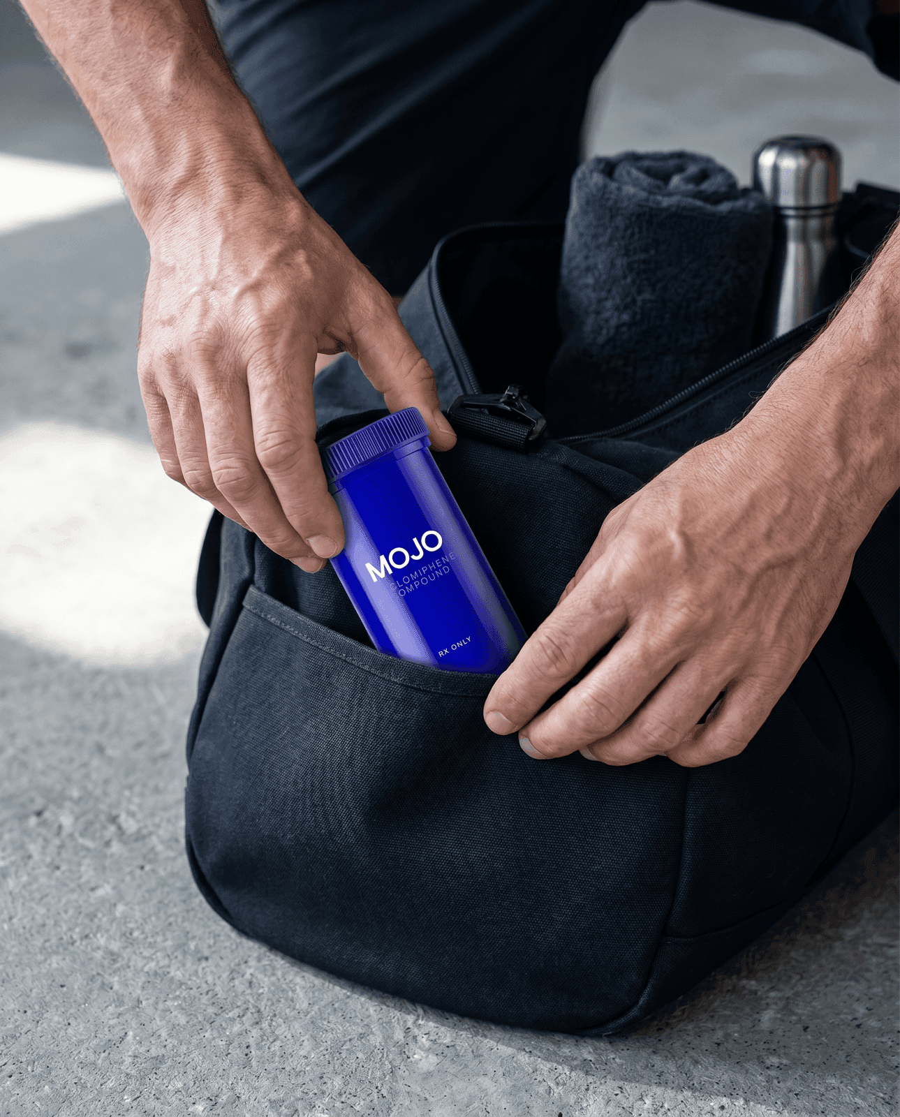 Strut Mojo Enclomiphene capsules bottle being placed into a duffle bag