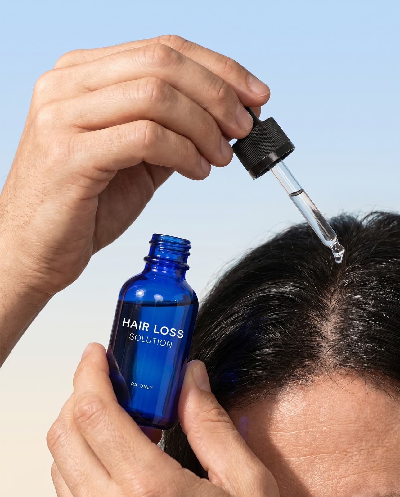 Applying Strut Hair Loss Solution with a dropper