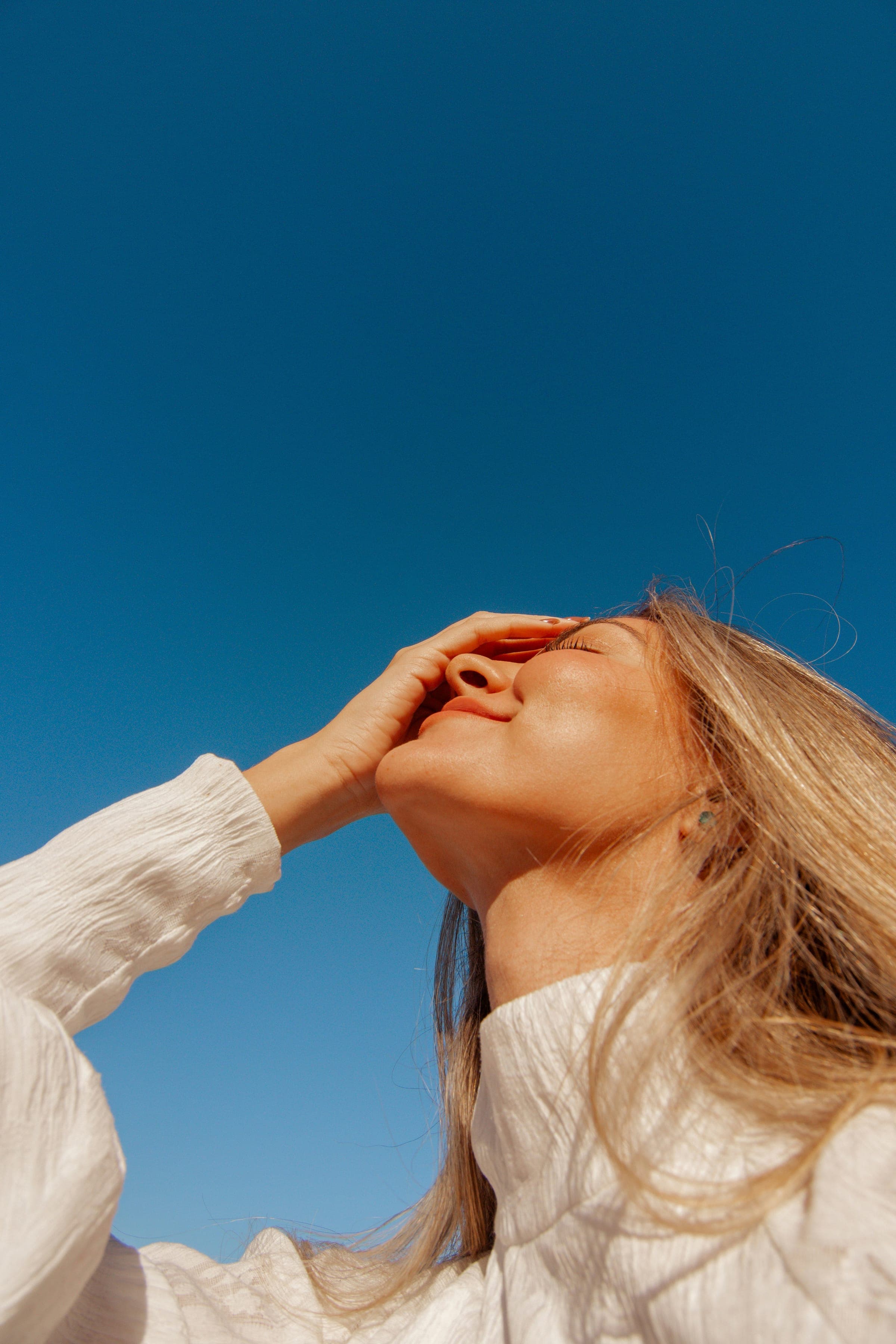 Woman running a hand through her hair in golden hour light