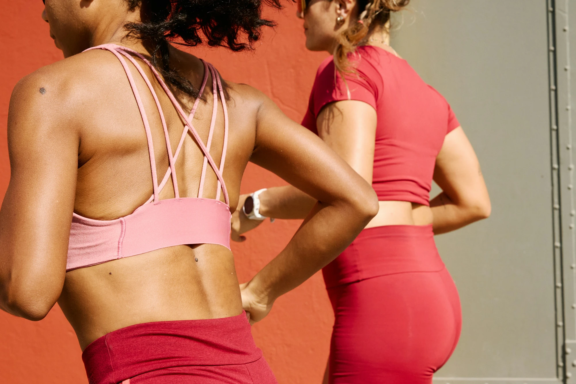 Two women in athletic wear checking a watch