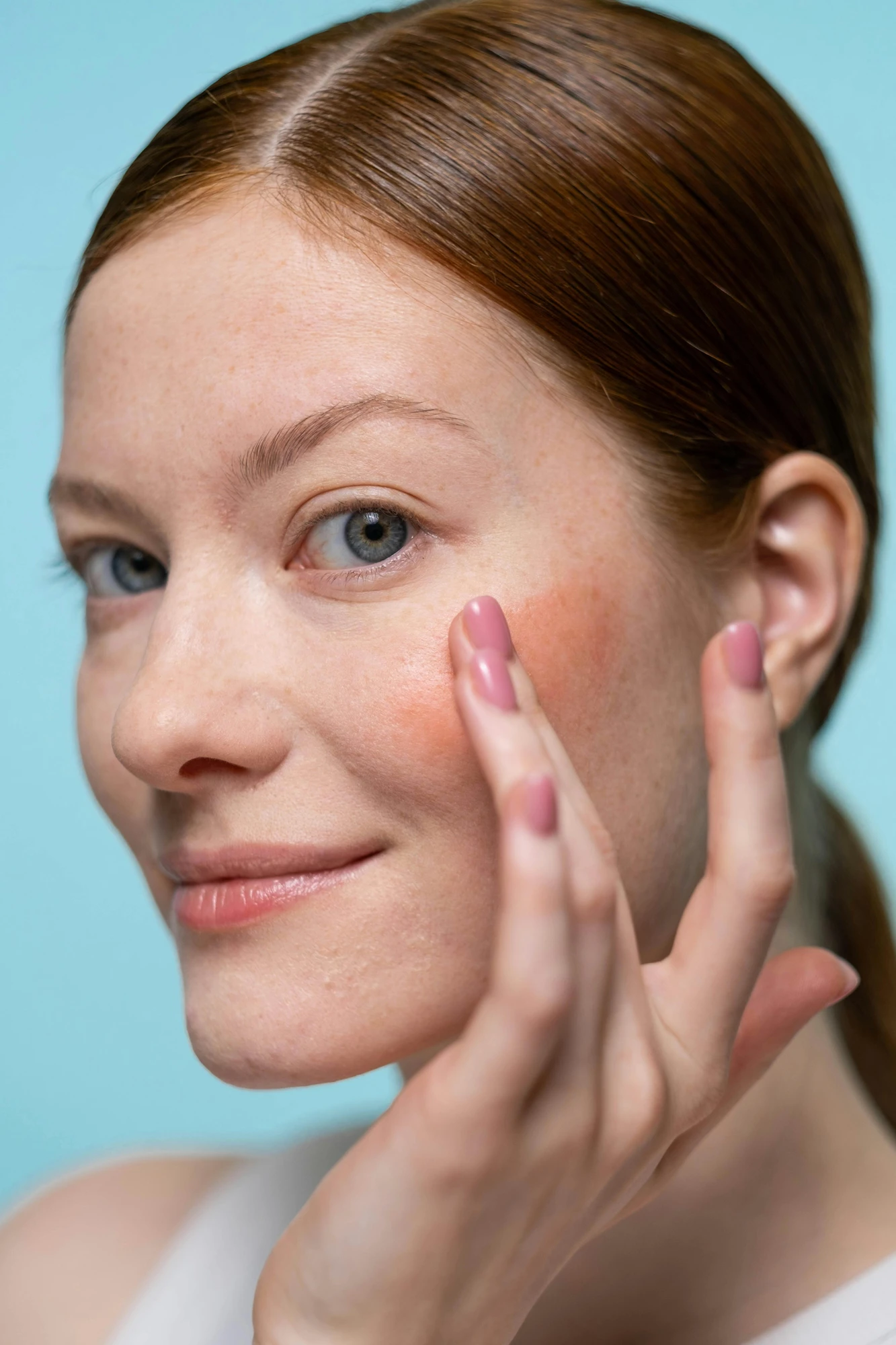 Applying skincare formula to the cheek