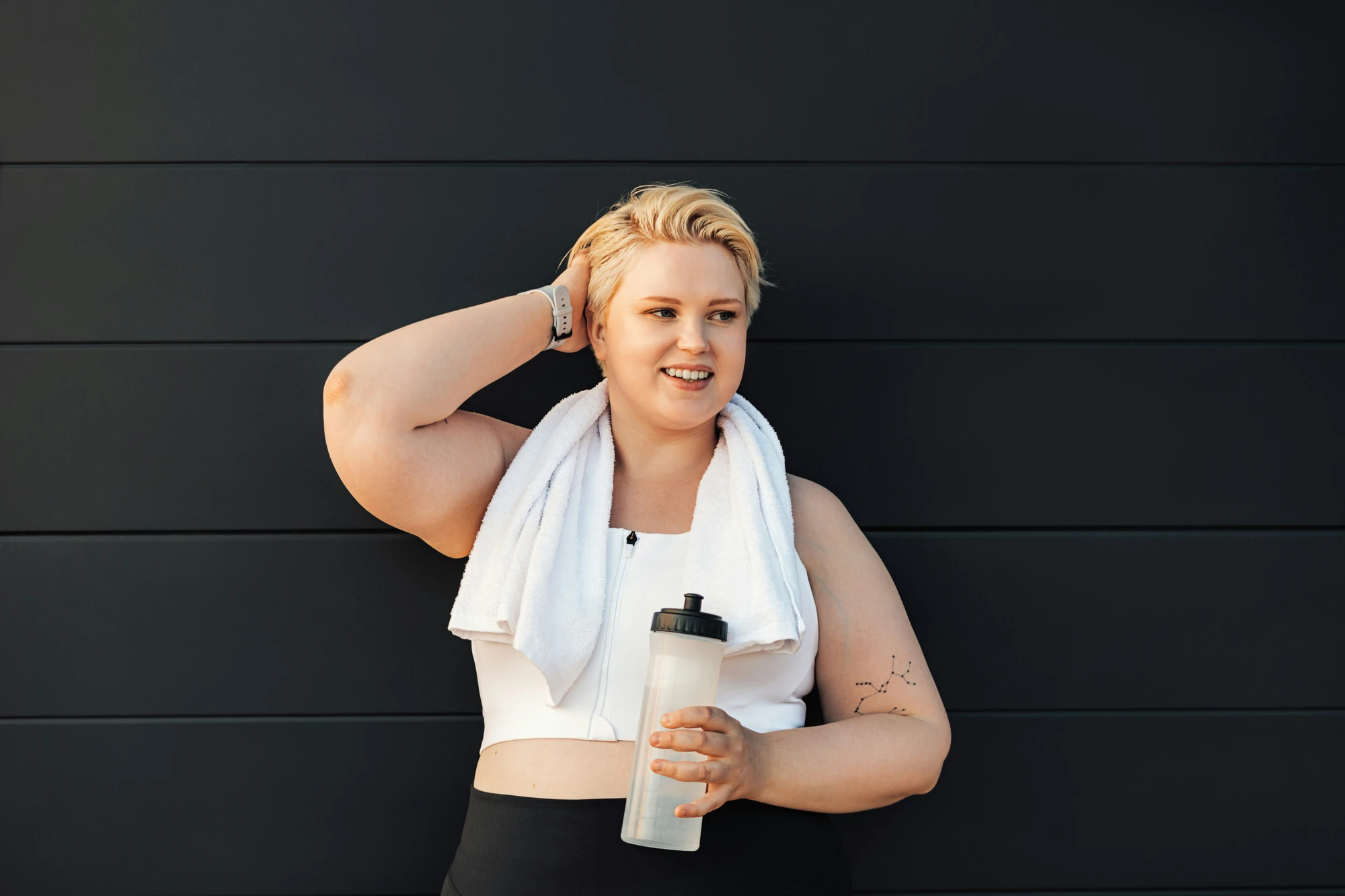 Woman with a towel and water bottle after a workout